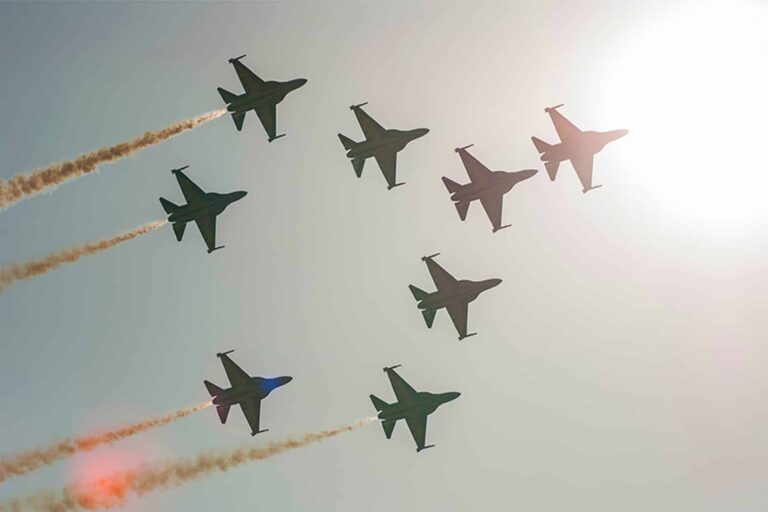 Silhouettes of eight T-50 jets up in the air, flying in formation